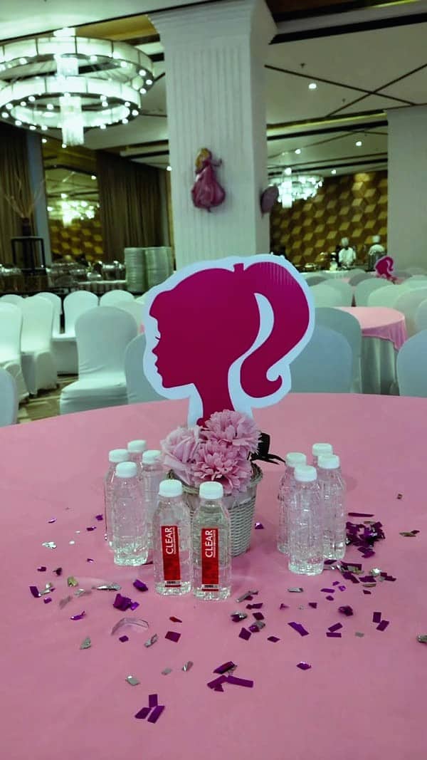 A pink Barbie-themed table with a silhouette centrepiece