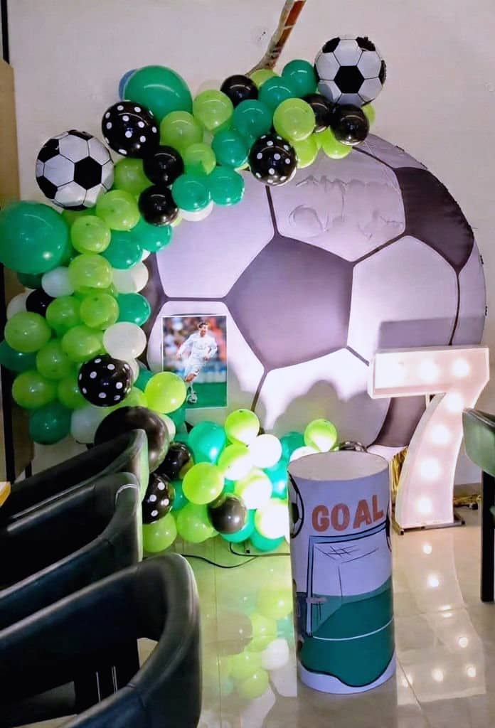 A football-themed balloon display with a giant football and goal props