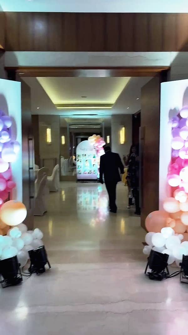 A hotel corridor lined with glowing balloon pillars
